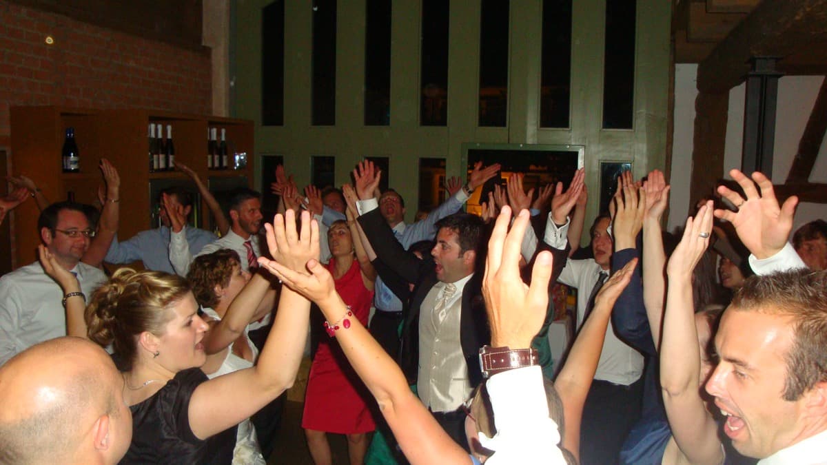 Gäste feiern mit Händen in der Luft